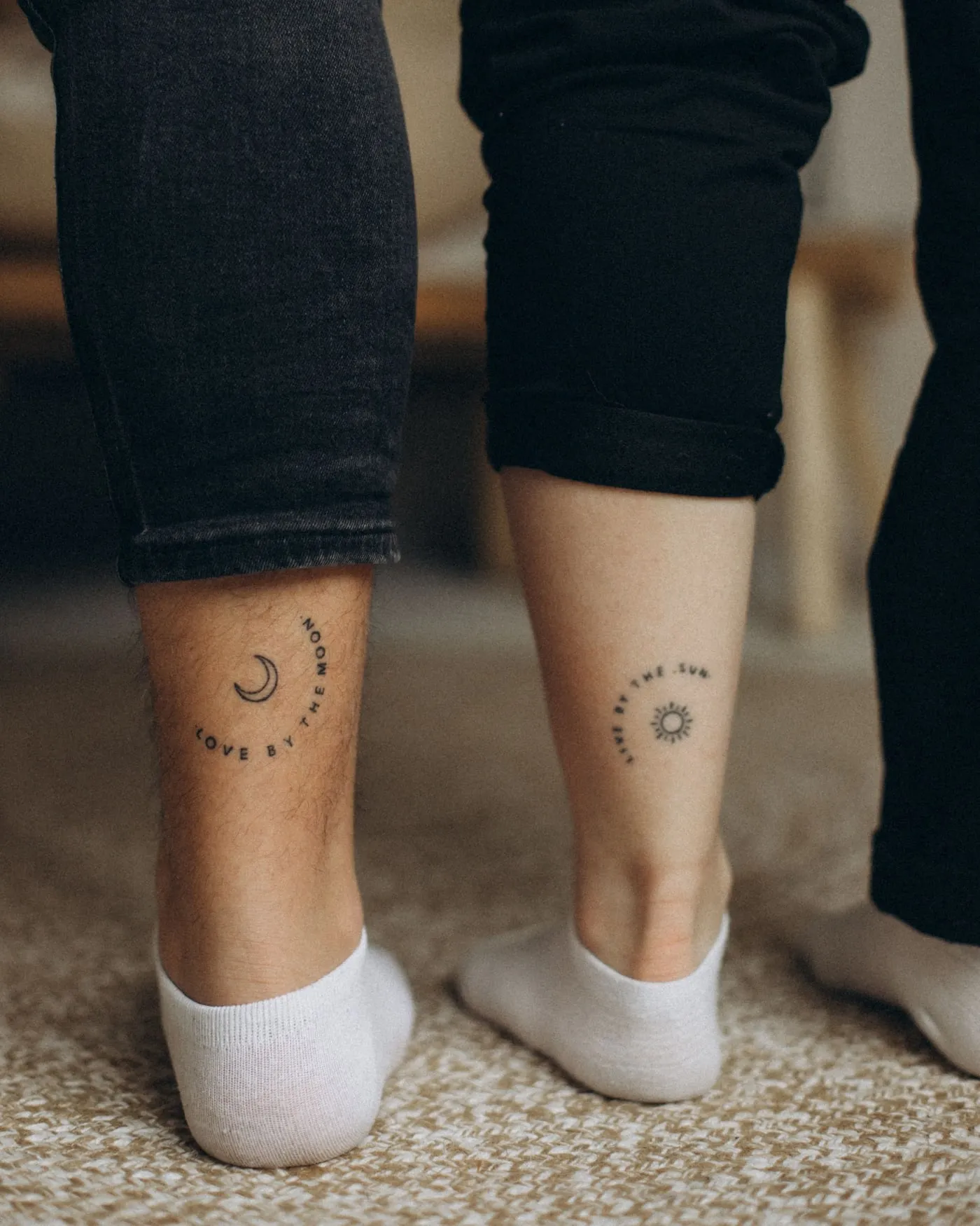 Two small fine-line tattoos on two ankles, photographed side by side on the day.