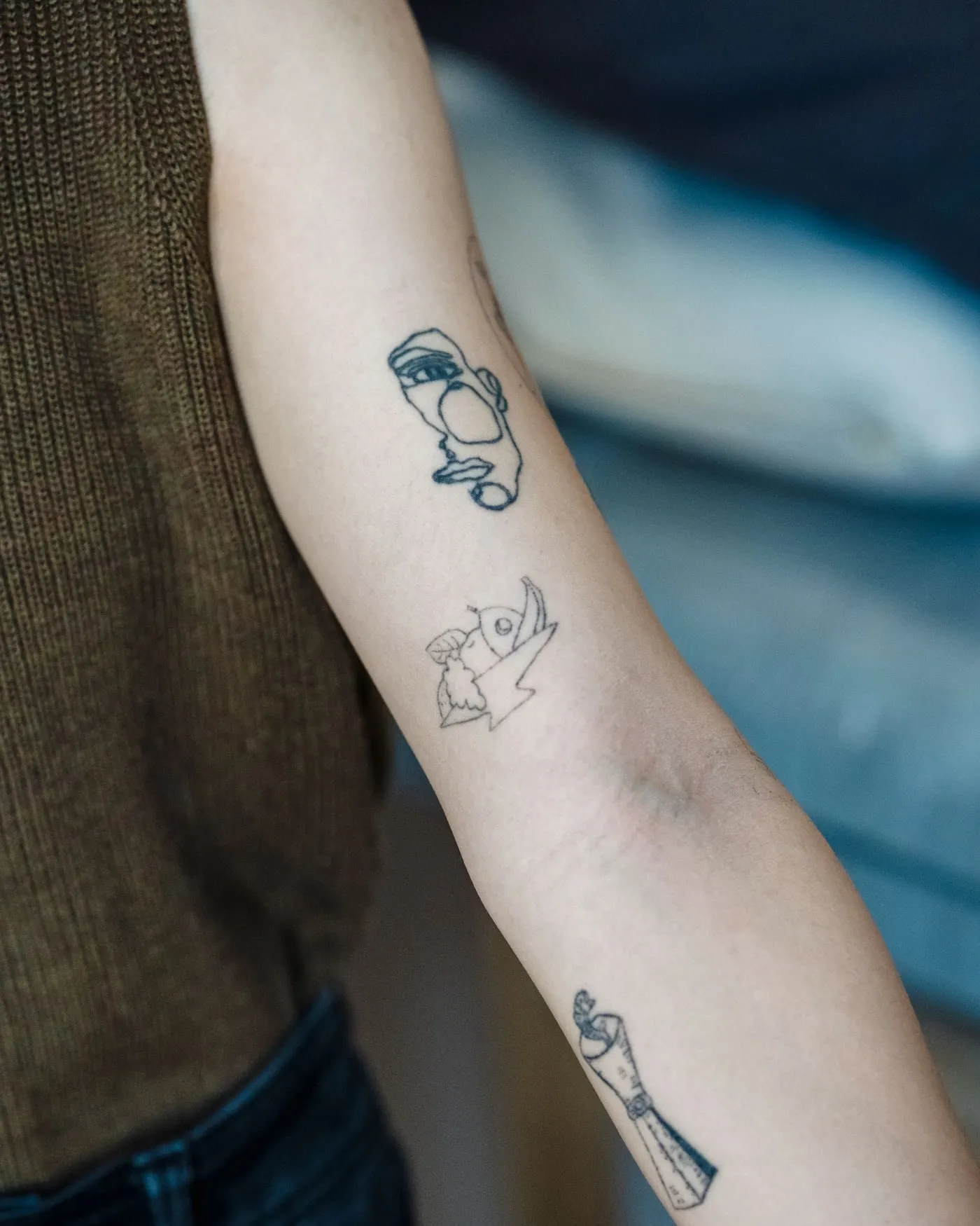Several small fine-line studies spaced along the outer forearm.