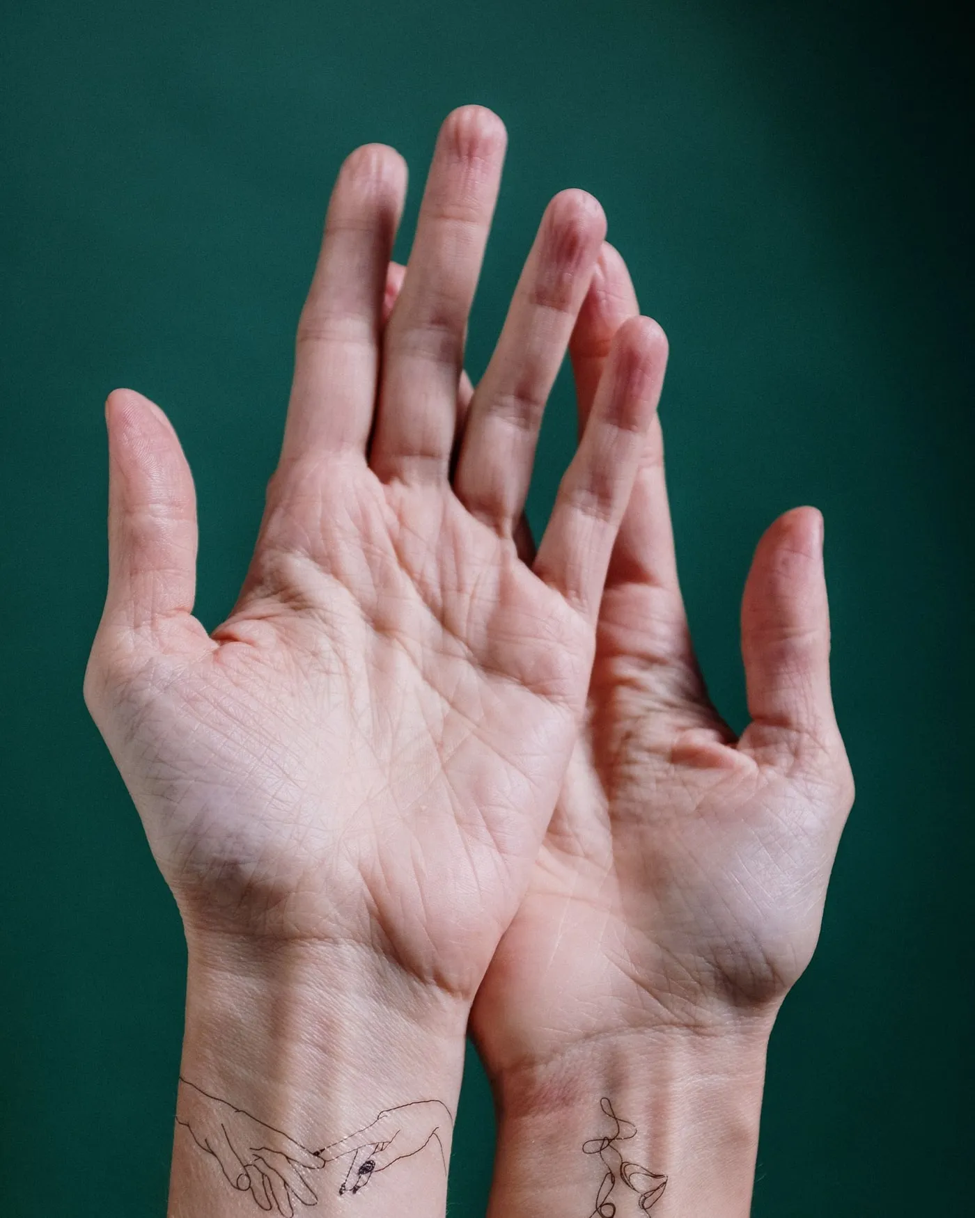 Hands photographed later, the geometric mark softened at the corners.